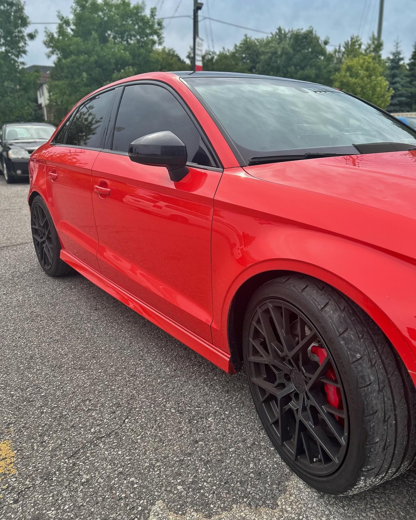 A red car is parked in a parking lot.