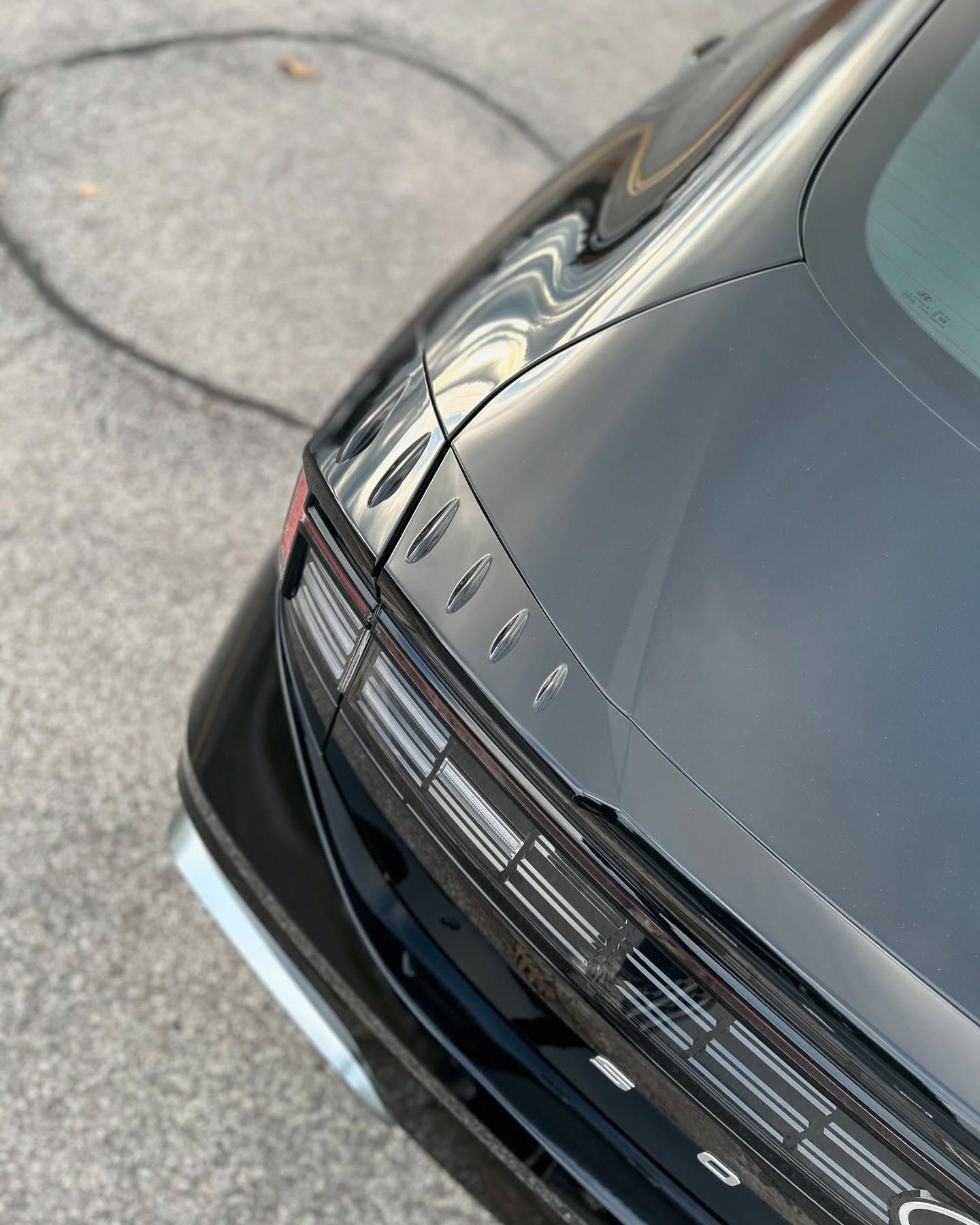 A black car is parked on the side of the road