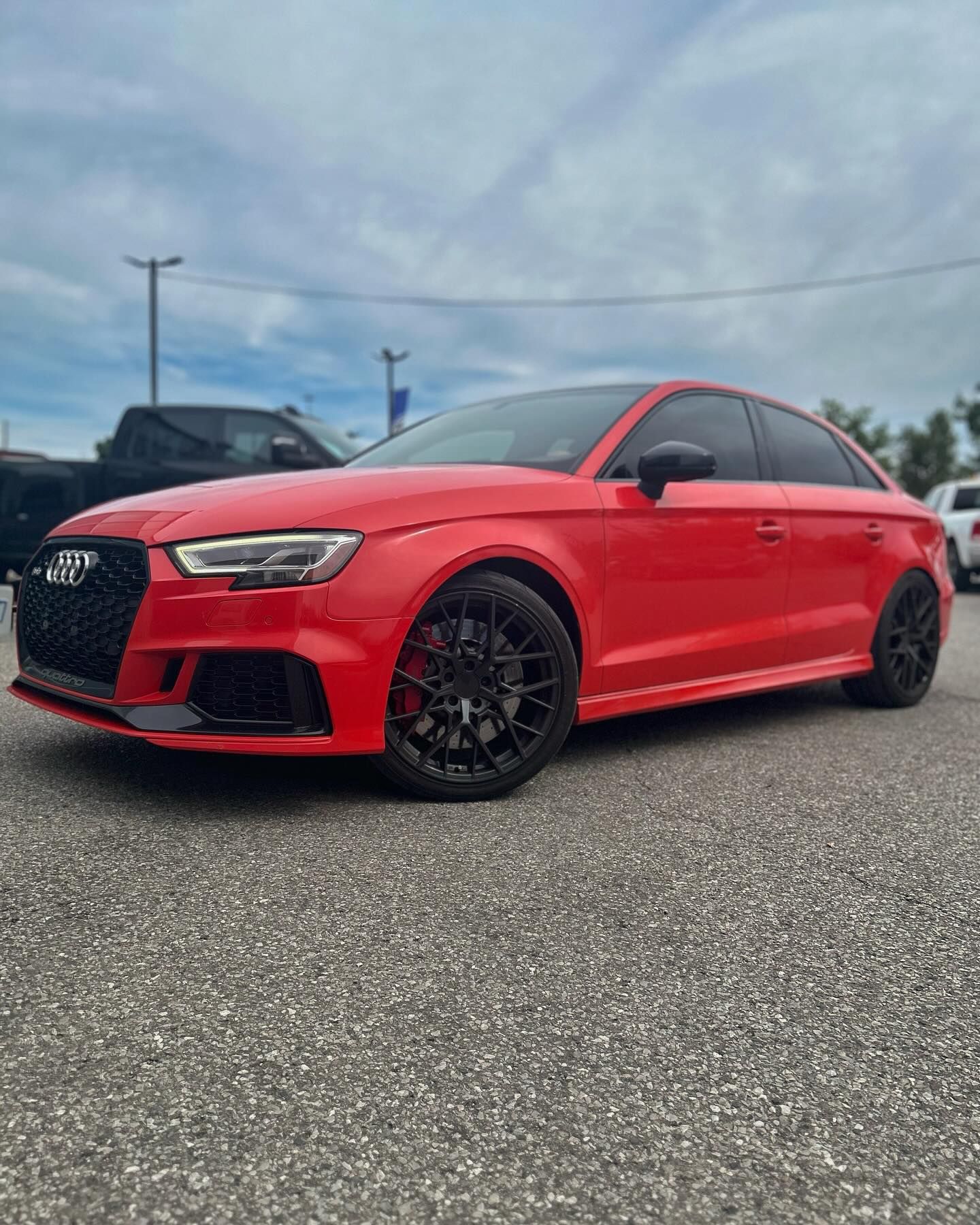 A red audi a3 rs is parked on the side of the road.