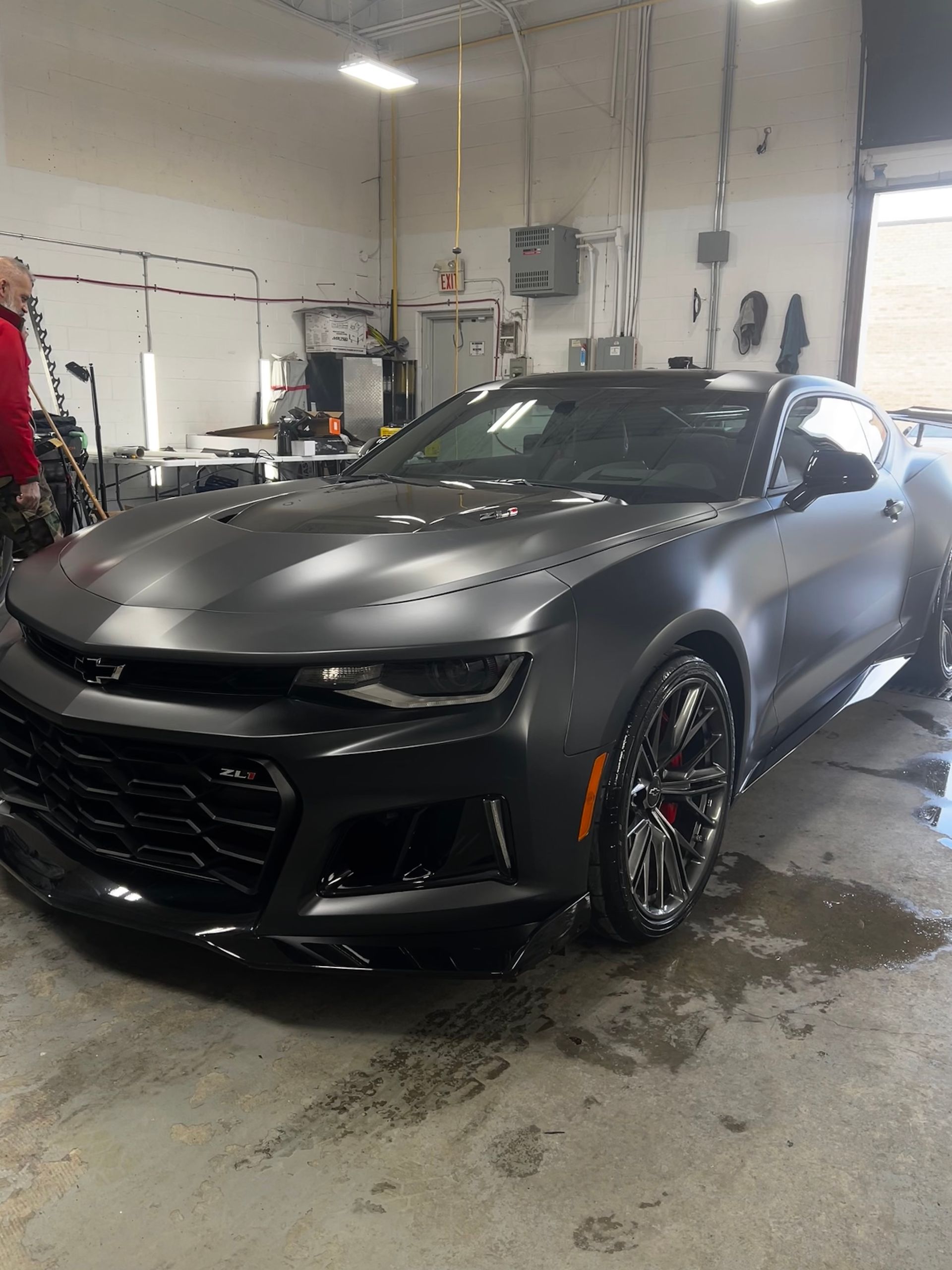 A gray car is parked in a garage.