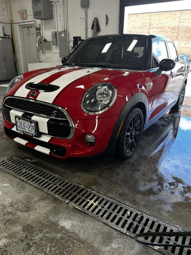 A red and white mini cooper is parked in a garage.