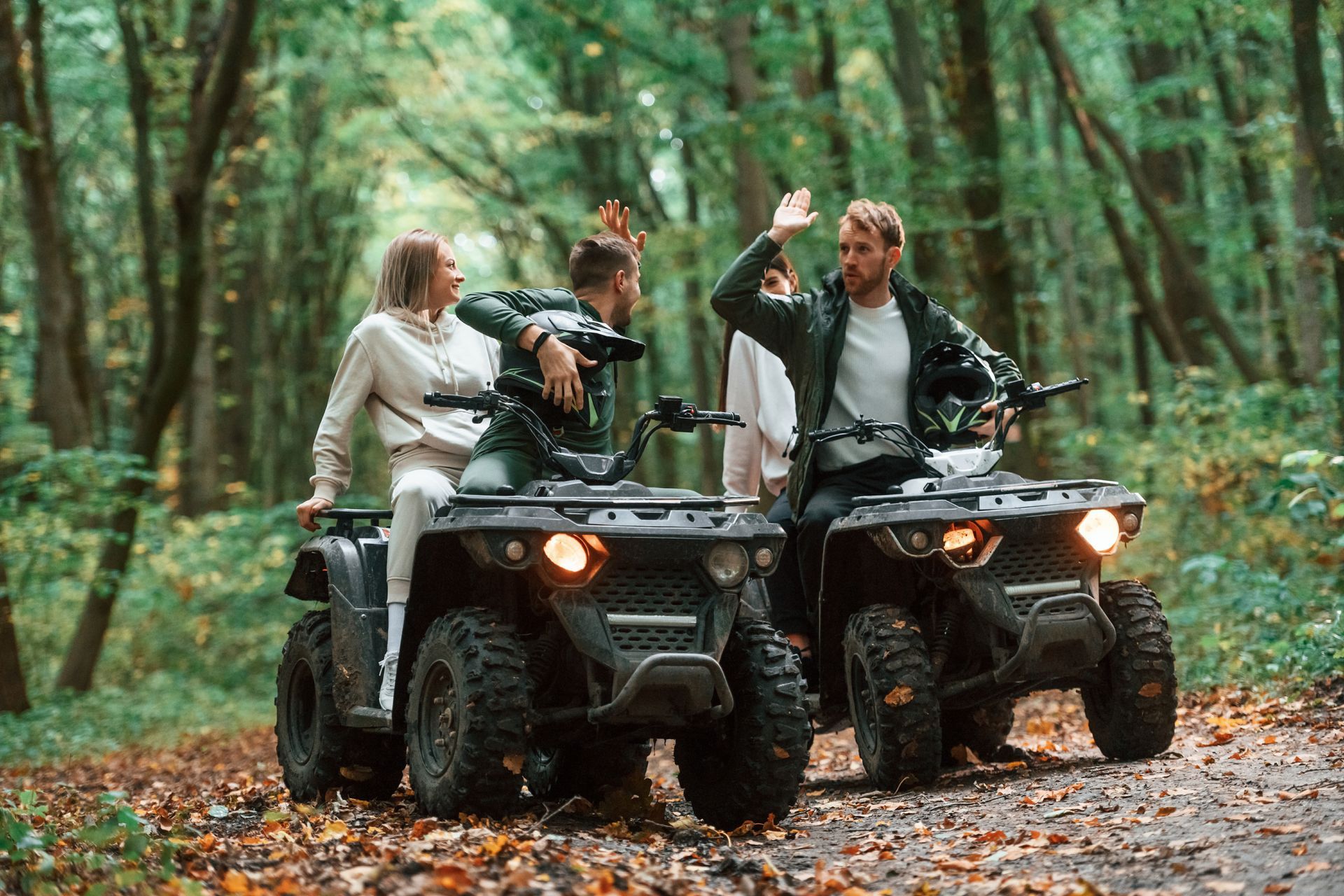 A group of people are riding atvs in the woods.