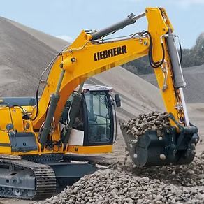 A Yellow Liebherr Excavator is Working on a Pile of Rocks — Hydrofit Service in Wollongong, NSW