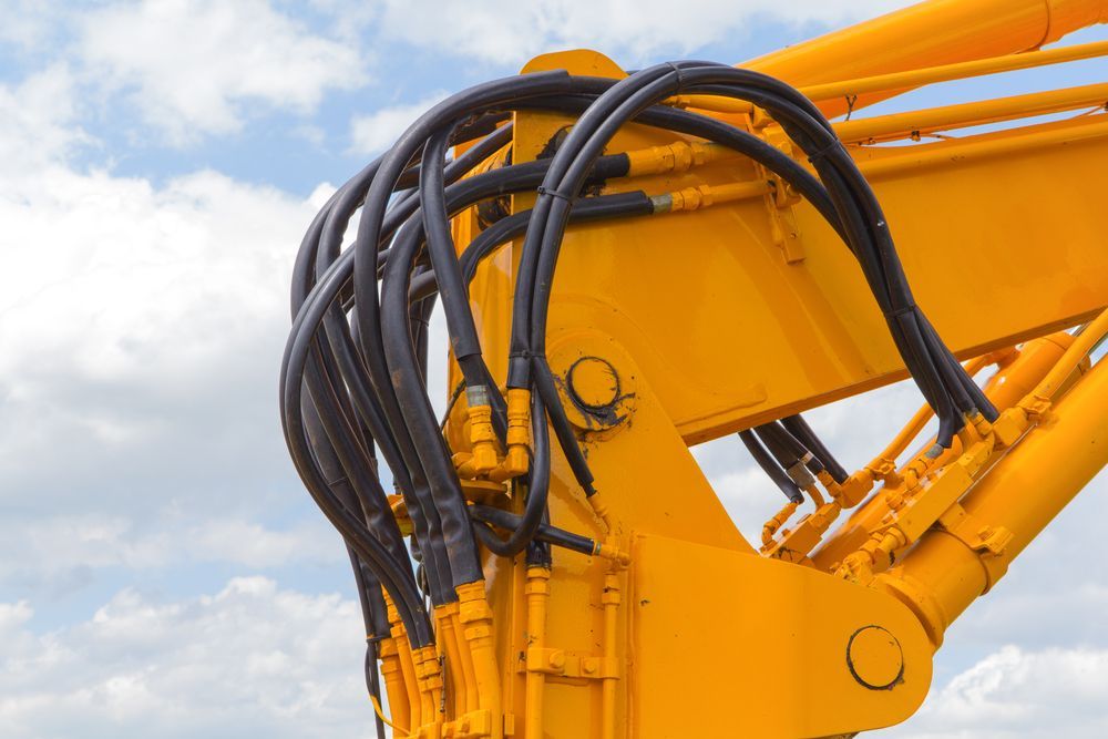 A Close Up of a Yellow Crane With Hydraulic Hoses Attached to It — Hydrofit Service in Campbelltown, NSW