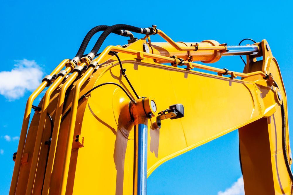 A Close Up of a Yellow Excavator Against a Blue Sky — Hydrofit Service in Campbelltown, NSW