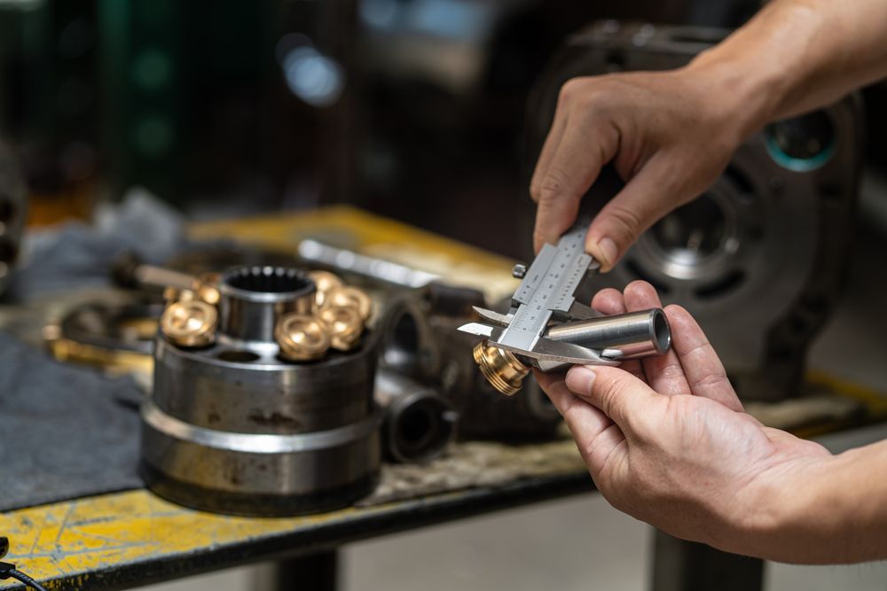 A Person is Measuring a Piece of Metal With a Caliper — Hydrofit Service in Wollongong, NSW