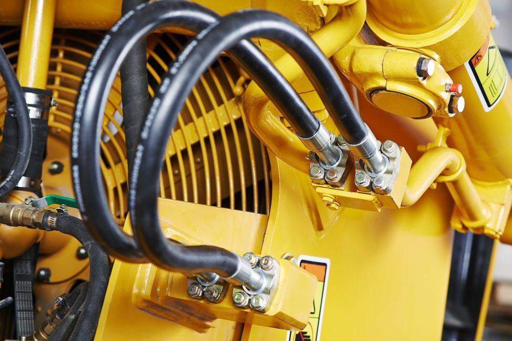 A Close Up of Hydraulic Hoses on a Yellow Machine — Hydrofit Service in Nowra, NSW
