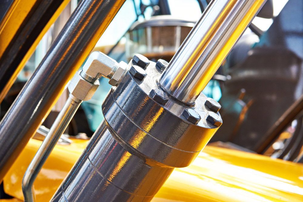 A Close Up of a Hydraulic Cylinder on a Yellow Vehicle — Hydrofit Service in Wollongong, NSW