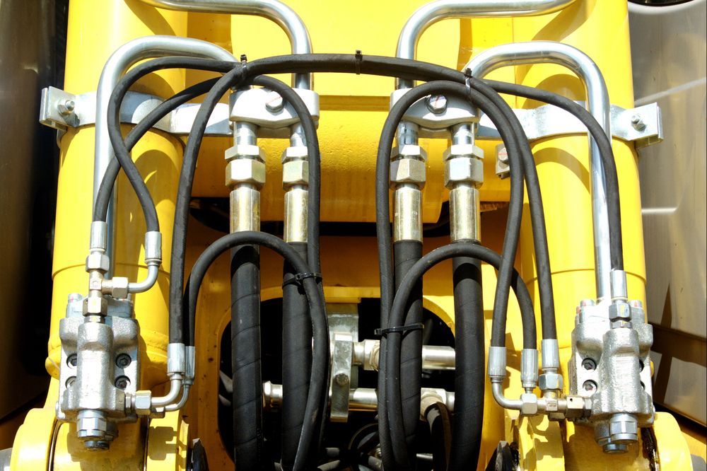 A Close Up of Hydraulic Hoses on a Yellow Machine — Hydrofit Service in Nowra, NSW