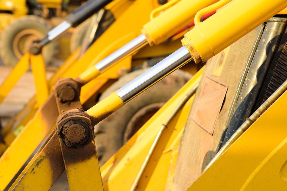 A Close Up of a Yellow Bulldozer With Hydraulic Cylinders — Hydrofit Service in Campbelltown, NSW