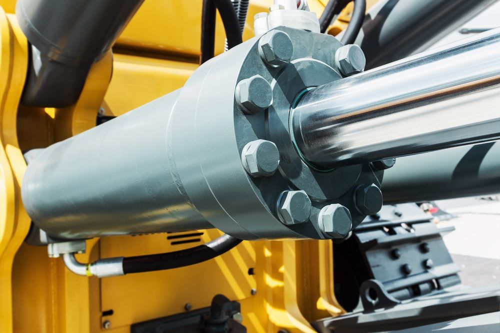 A Close Up of a Hydraulic Cylinder on a Yellow Vehicle — Hydrofit Service in Wollongong, NSW