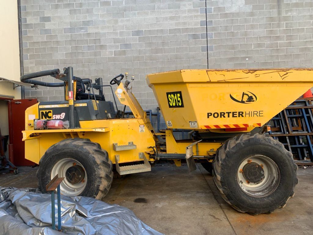 A Yellow Dump Truck is Parked in Front of a Brick Wall — Hydrofit Service in Shellharbour, NSW