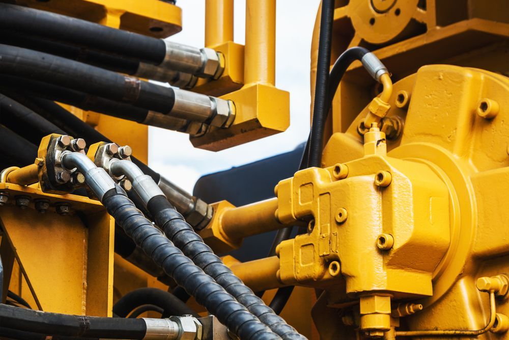 A Close Up of Hydraulic Hoses on a Yellow Machine — Hydrofit Service in Shellharbour, NSW
