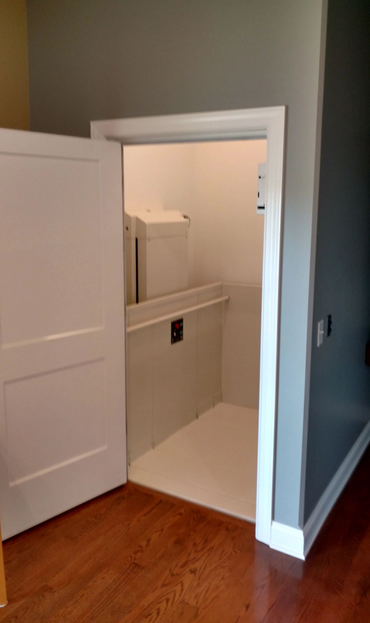 A room with a door open and a toilet in it.