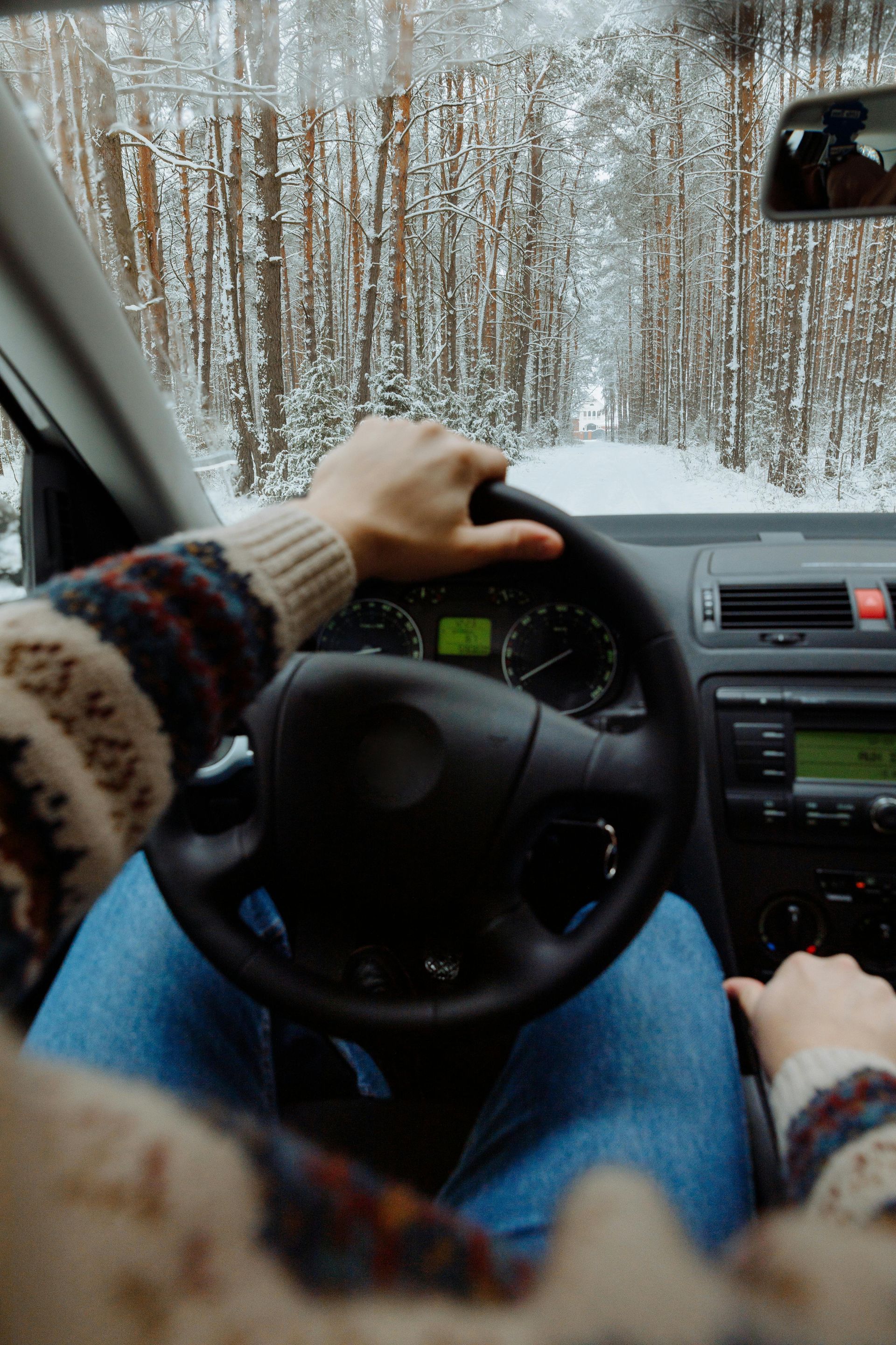 A person is driving a car in the snow.