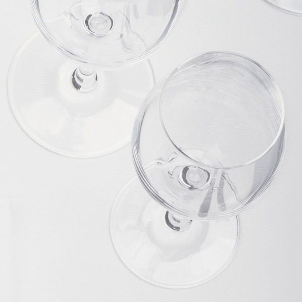 Tre bicchieri di vino sono appoggiati su un tavolo bianco.