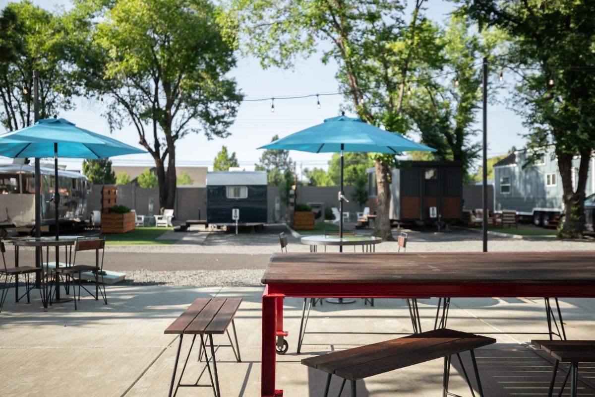 a picnic area with tables and benches and blue umbrellas .