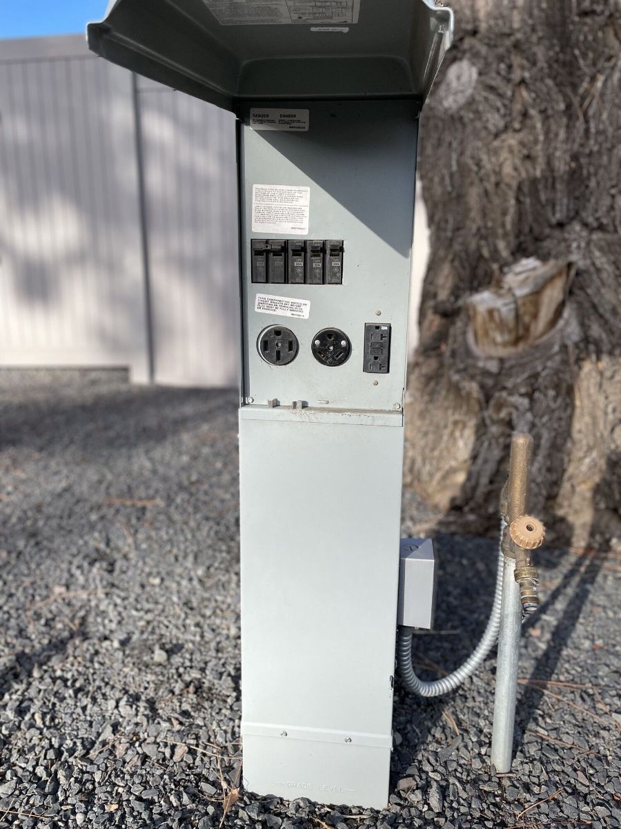 a electrical box is sitting on the ground next to a tree .