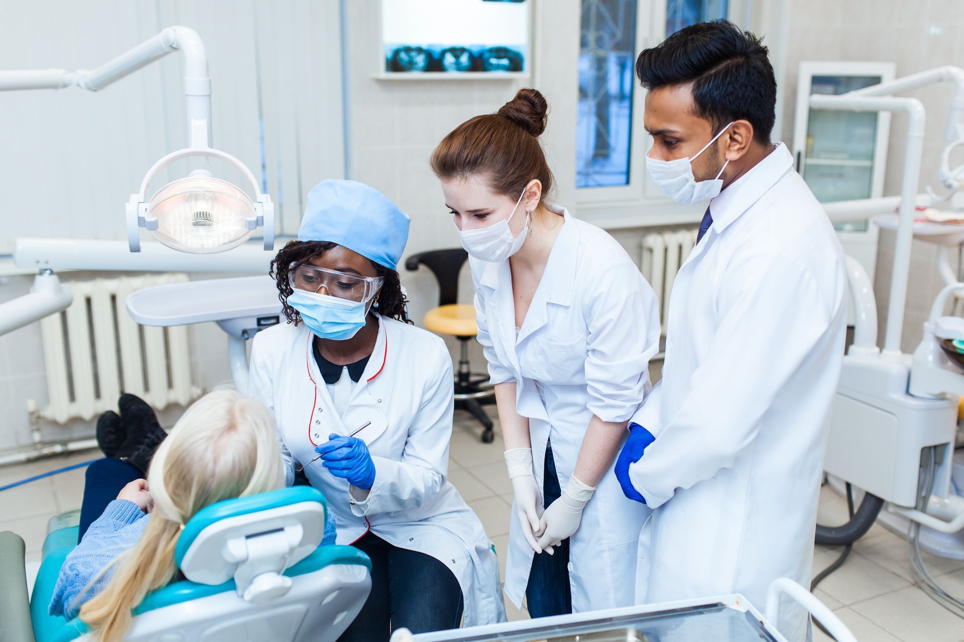 Dental professionals provide collaborative patient care in a clinical environment.