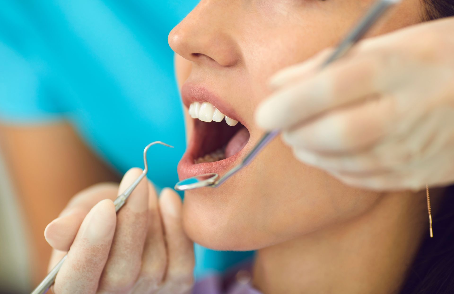 Dentist using a dental tool during an oral checkup.