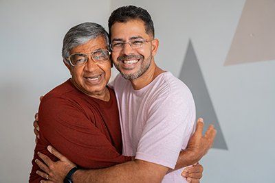 Father and Son Hugging — Memphis, TN — Plaza Dental Offices An image of two people involved in a dental group serving Memphis, TN