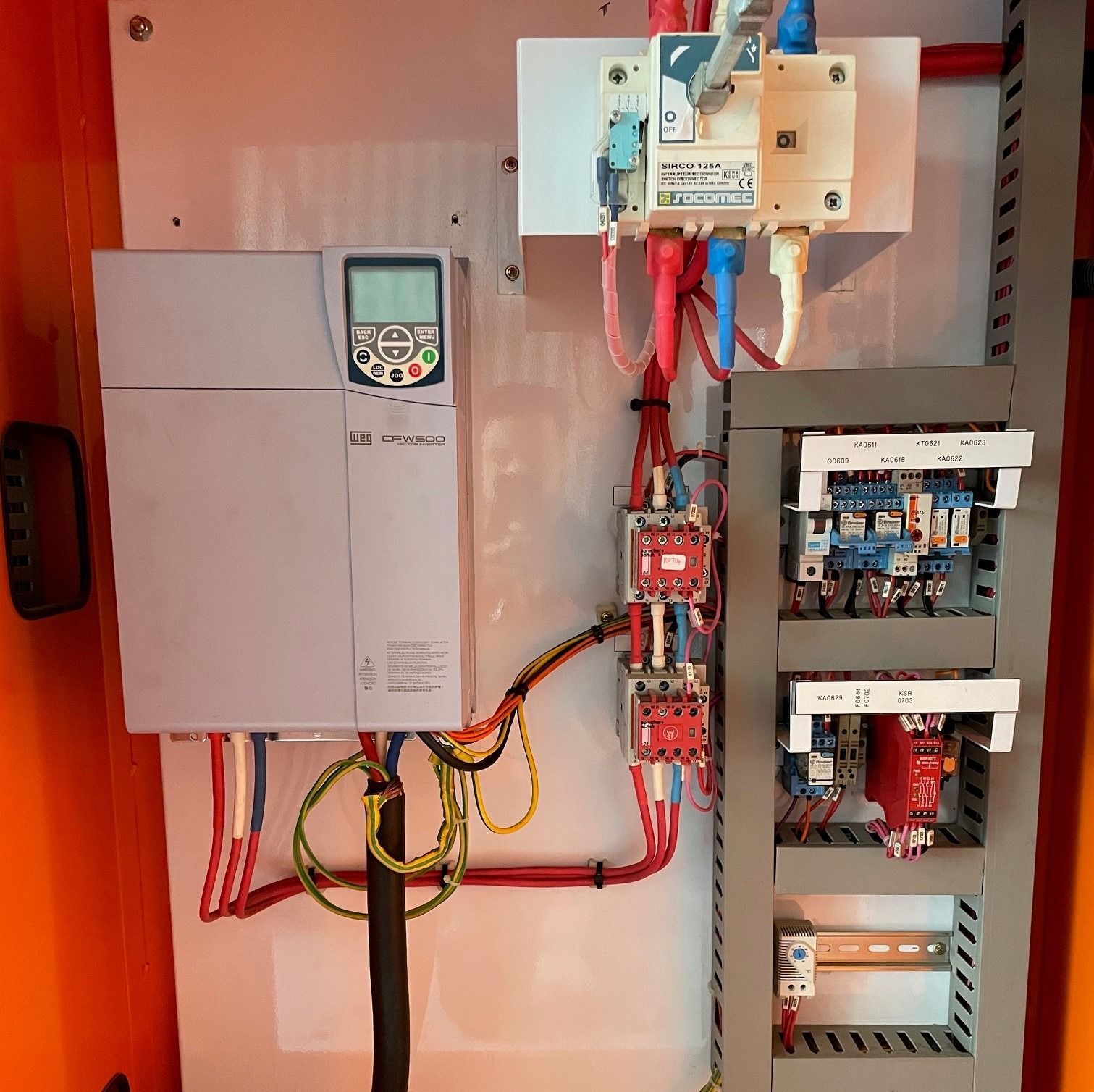 An industrial electrical control panel featuring a variable frequency drive, a main disconnect switch, and circuit breakers.