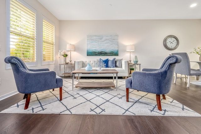 The living room of a HOA home is pictured with cream couches, dark wood floors and modern home decor.