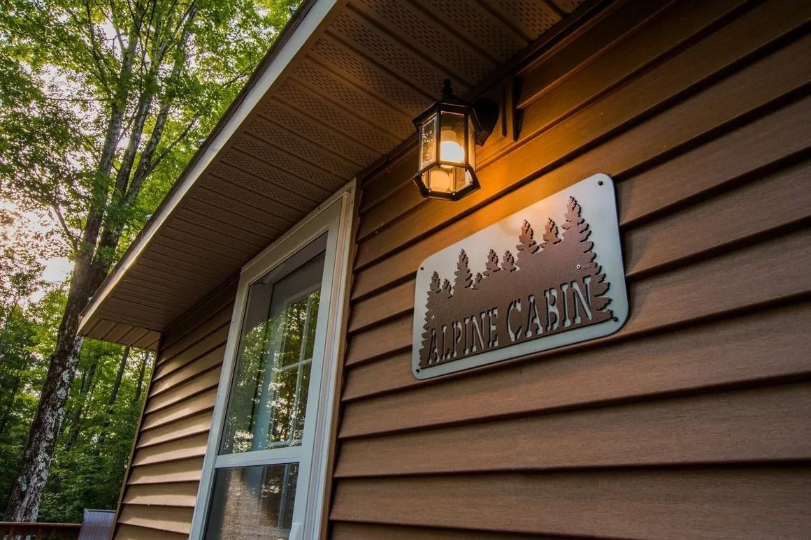 A wooden cabin with a sign on the side of it.