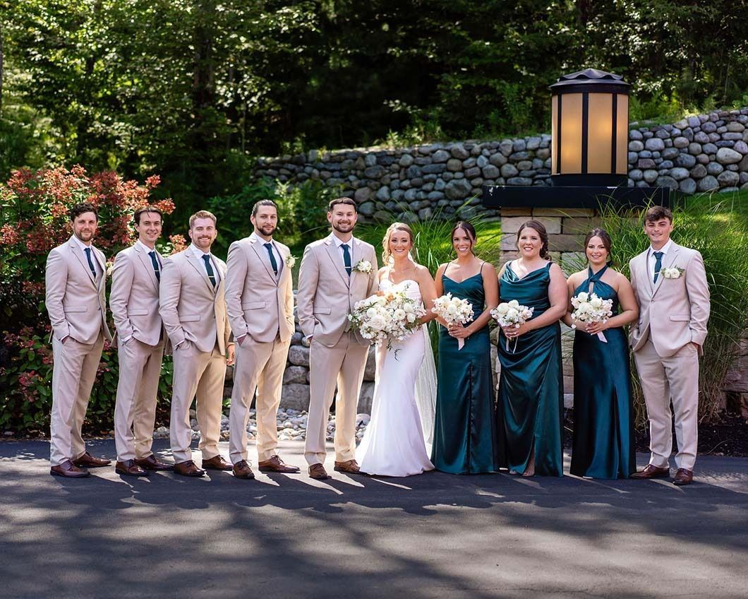 The bride and groom are posing for a picture with their wedding party.