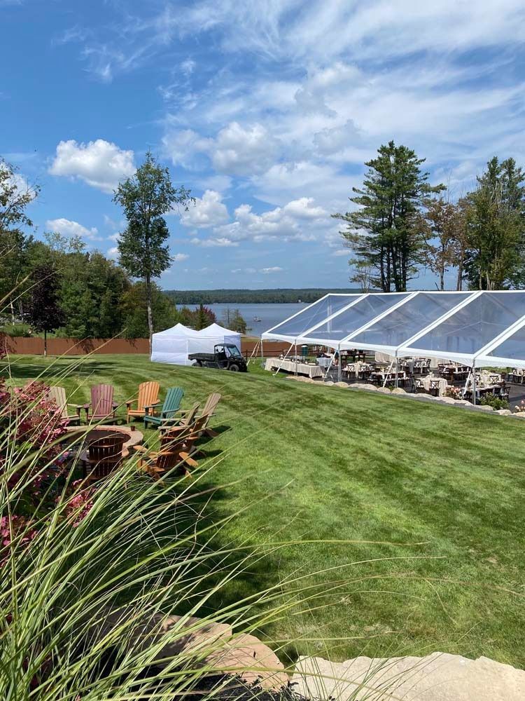 A large clear tent is sitting in the middle of a lush green field.