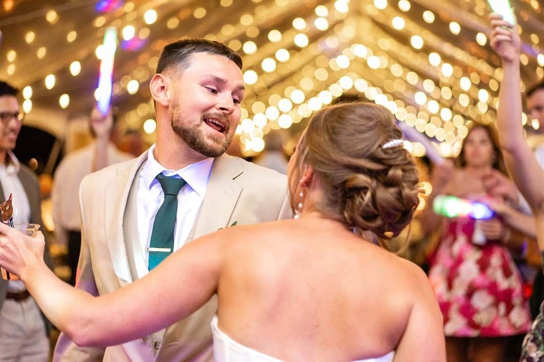 A bride and groom are dancing at their wedding reception.