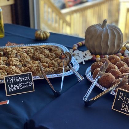 A table with stuffed mushrooms and rice balls on it