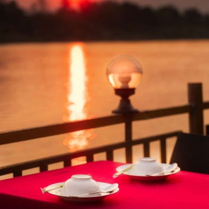 Two bowls on a red table with a sunset in the background