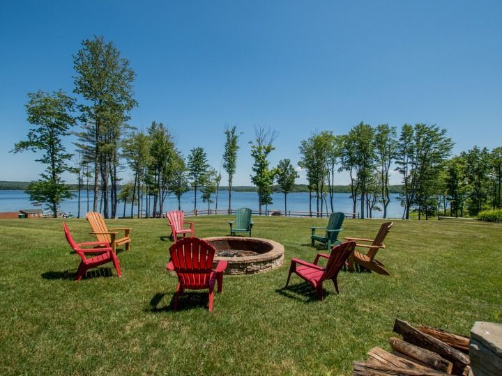 A group of chairs are sitting around a fire pit.