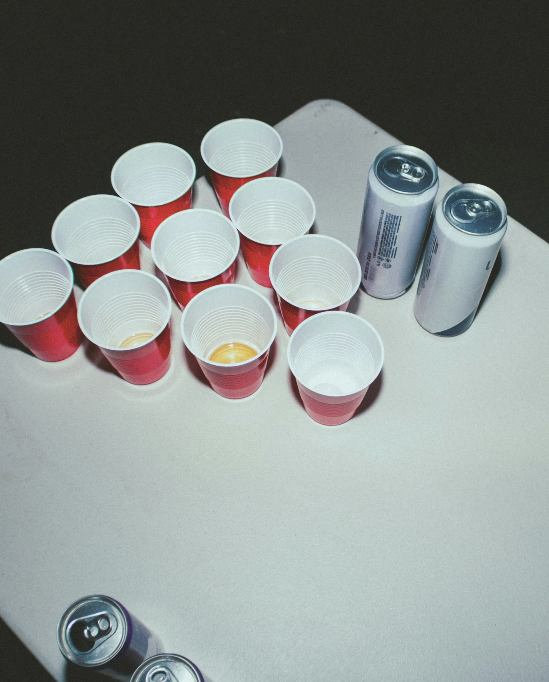 Plastic cups lined up on a table for a beer pong game.