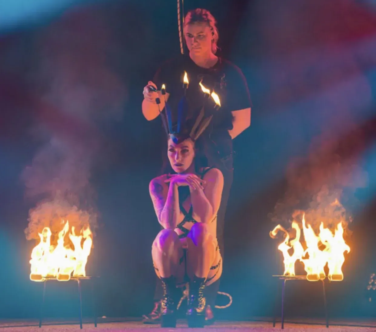 Fire dancer with fire safety officer lighting up her fire crown.