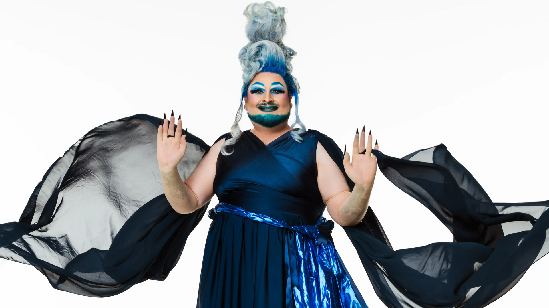 Drag queen in blue Hades-inspired gown with flowing black fabric.