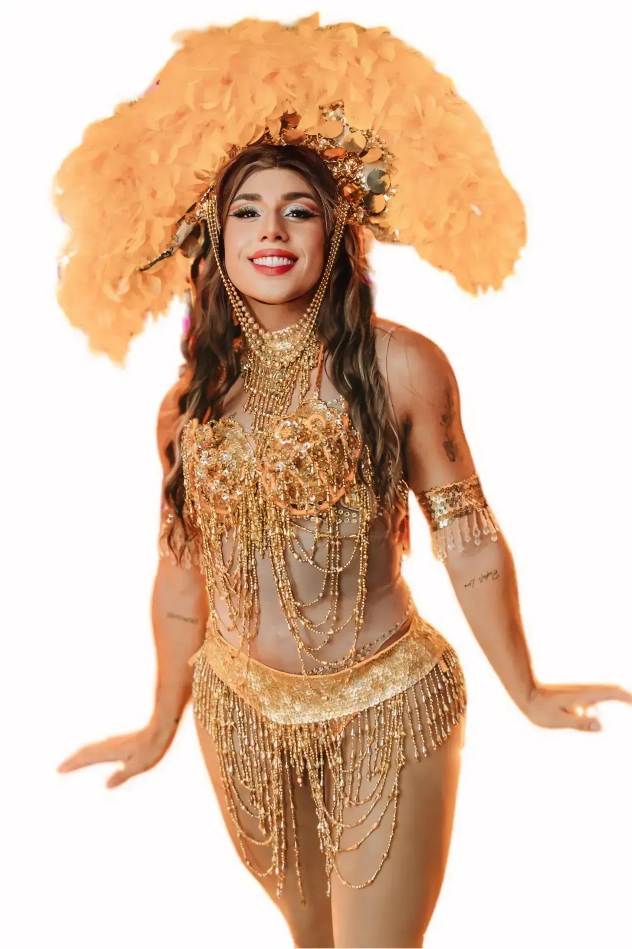 Drag performer in golden costume with feathered headdress, smiling.