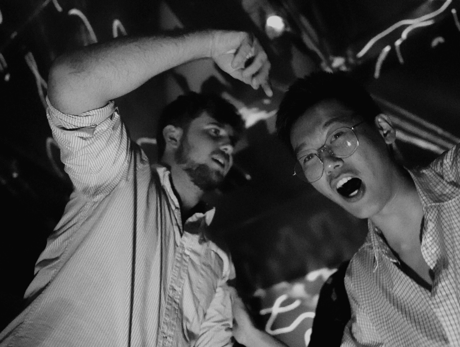 Two men dancing in nightclub black and white energetic moment (also off-brand)