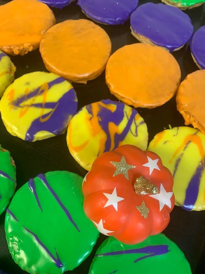 Cookies with colorful icing, and a small decorative pumpkin.