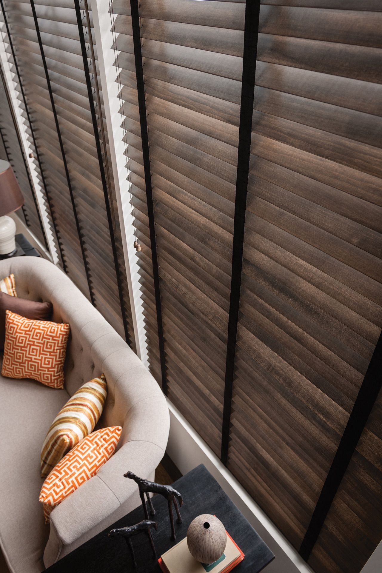 Kitchen with double sink, window with blinds, and dark wood cabinets.