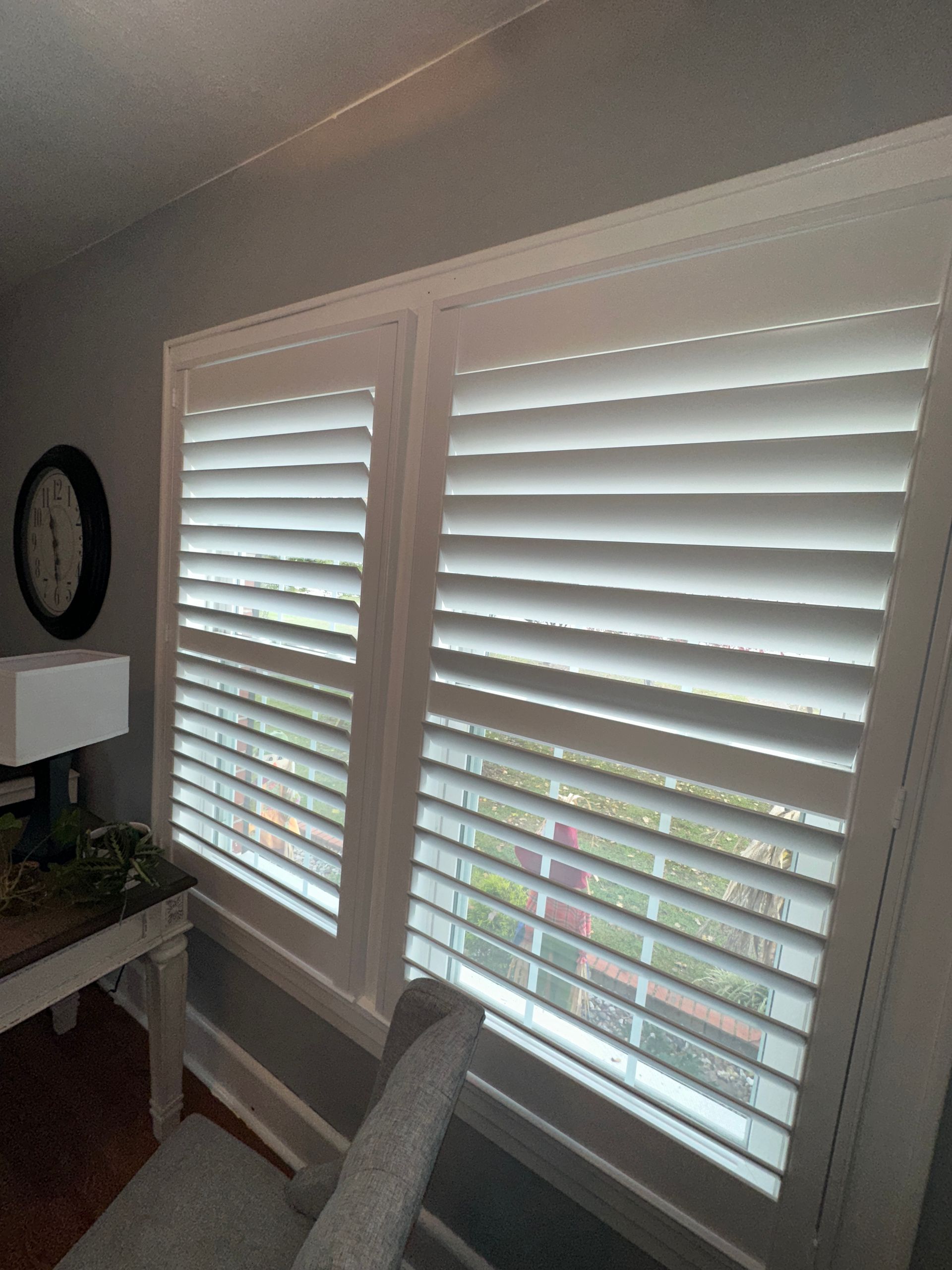 grey -walled room office, shuttered windows, and clock 