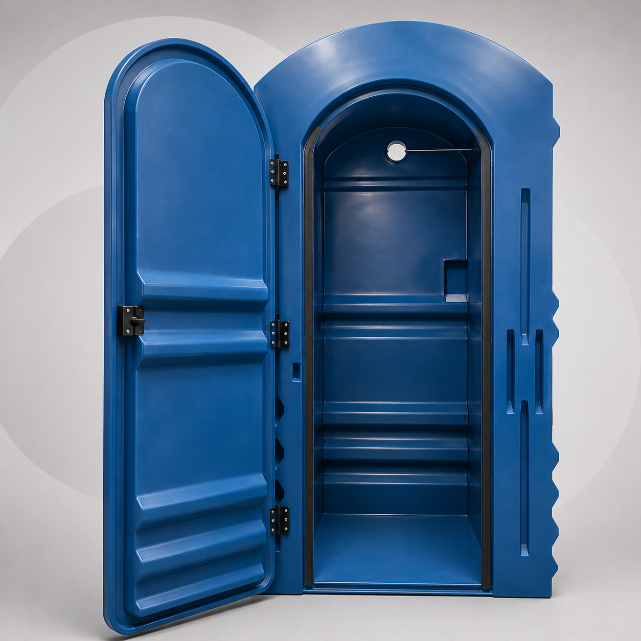 Baño portátil verde junto a una cabina telefónica plateada en un parque, con árboles y césped cerca.
