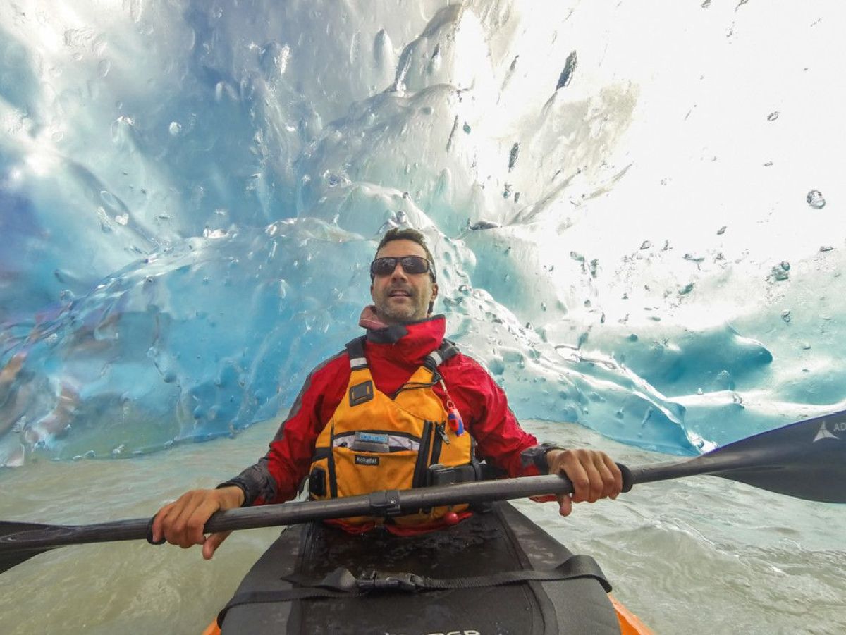 A man is riding a kayak through an ice cave.