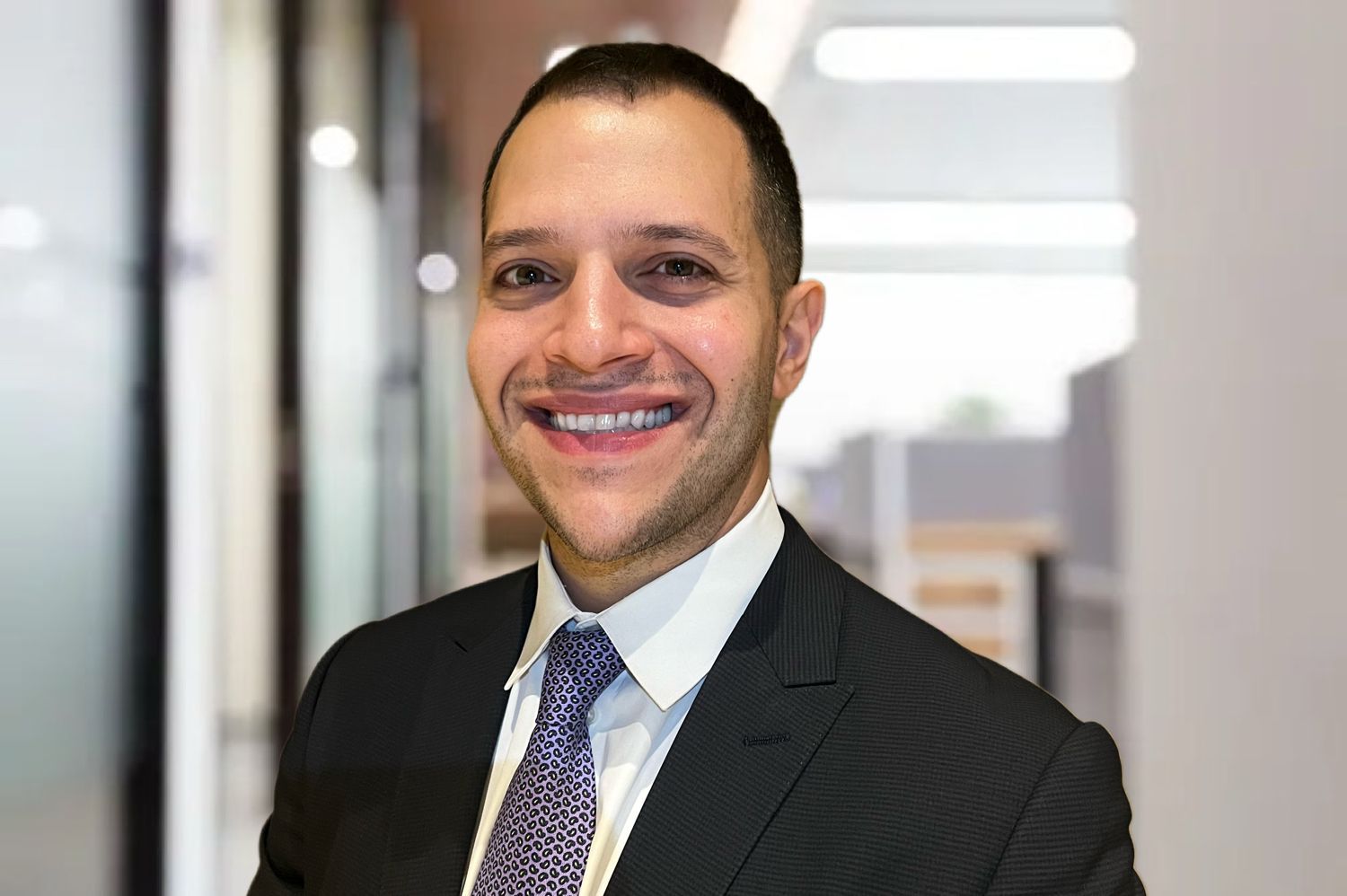 A man in a suit and tie is smiling for the camera.