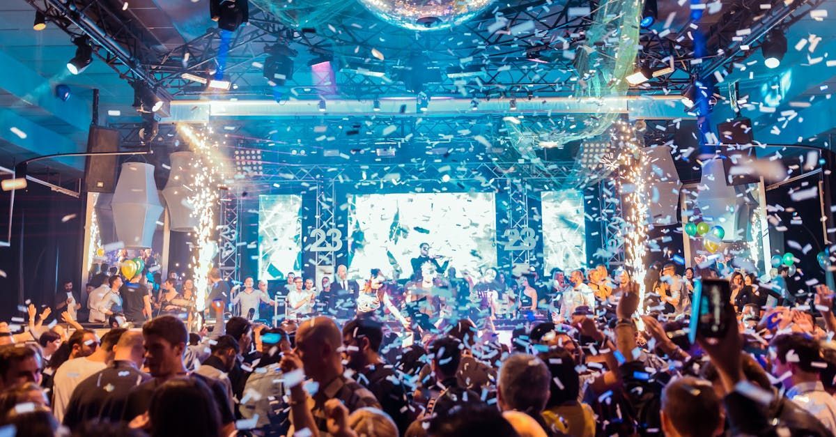 A crowd of people are standing in front of a stage at a concert.