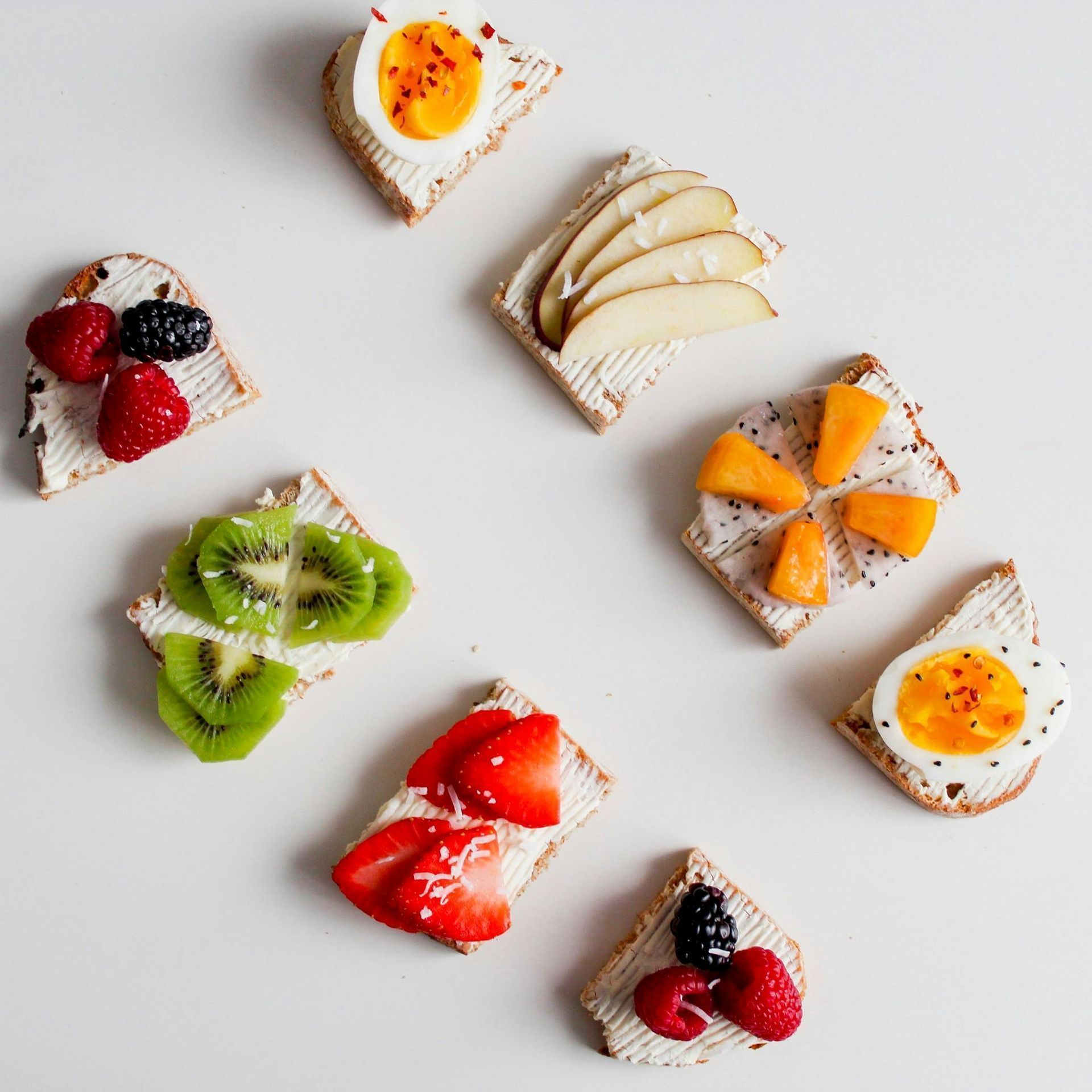 Lined up bread with various fruit and other toppings