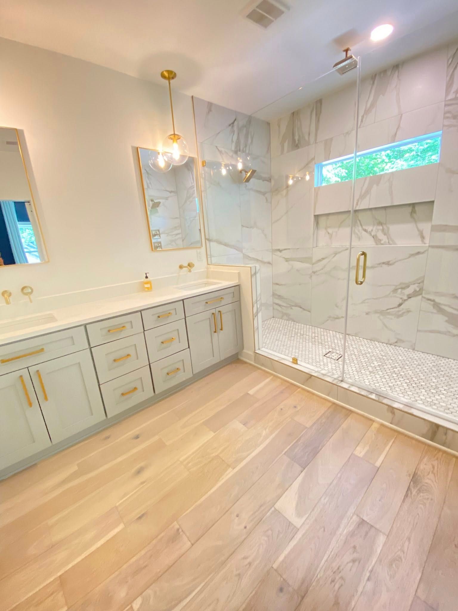 A bathroom with a walk in shower , sink and mirror.