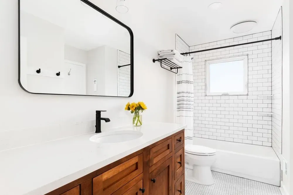 A bathroom with a sink , toilet , tub and mirror.