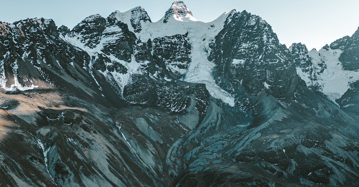 A mountain covered in snow with a blue sky in the background